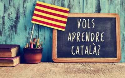 Pizarra con el texto Vols aprendre català junto a una bandera catalana